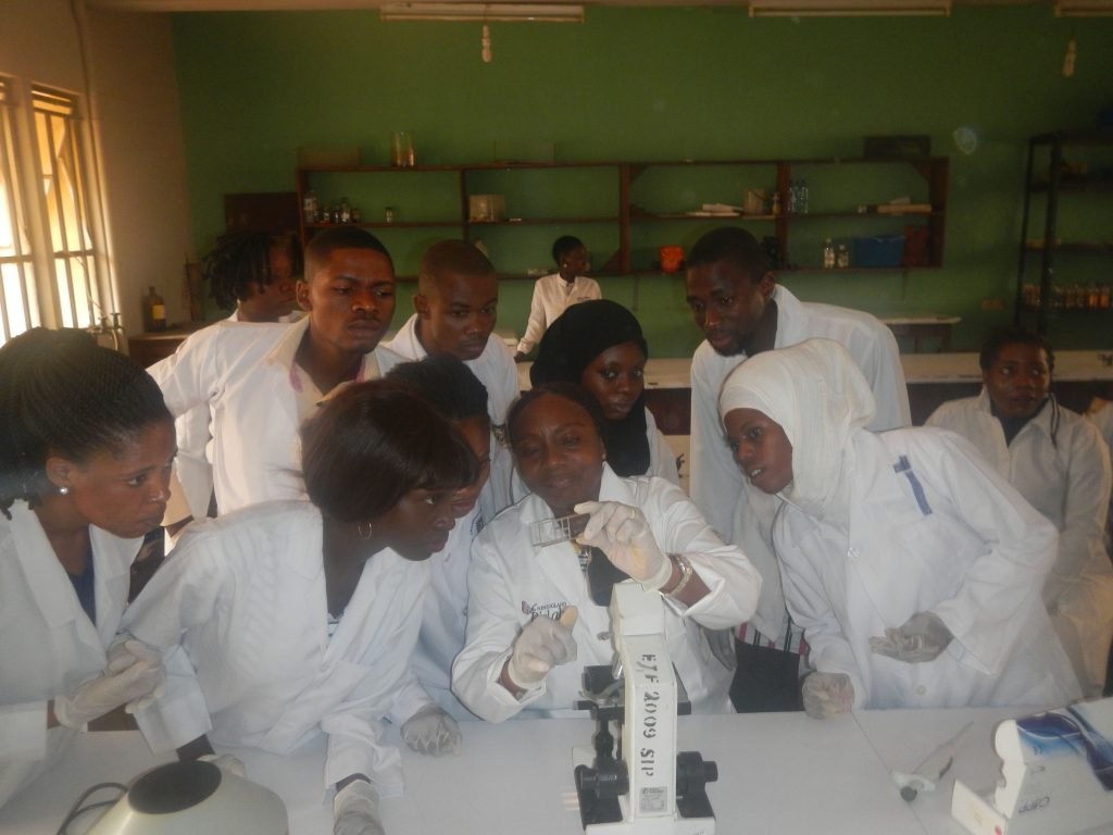 Dr. Henrietta Awobode demonstrates Trypanosoma brucei identification and counts for DEAE cellulose chromatography to postgraduate Parasitology students