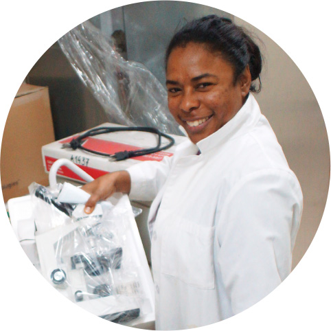 A female researcher unboxing equipment and smiling at the camera