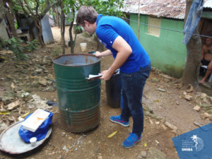An Institute research assistant examines standing water in a barrel in search of mosquitoes.
